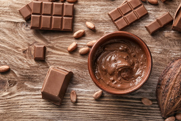 Flat lay composition with delicious chocolate on wooden background
