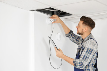 Electrician inspecting surveillance camera