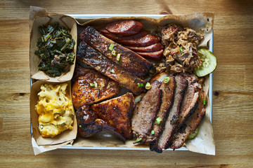 texas bbq style tray with smoked beef brisket, st louis ribs, chicken and hot links - obrazy, fototapety, plakaty
