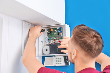 Electrician installing alarm system - obrazy, fototapety, plakaty