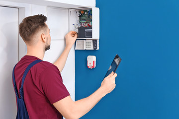 Electrician inspecting alarm system