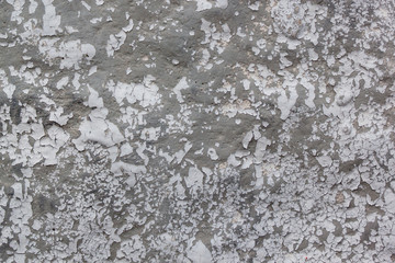 Rough painted wall with pieces of gray paint. Seamless texture. Used as a background.
