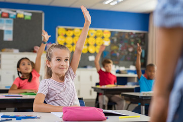 Fototapeta Children raising hands in classroom obraz