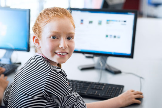 Pupil girl using computer at school