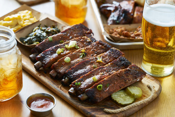 st louis style bbq ribs on table top with sweet tea, beer, collard greens and mac & cheese - obrazy, fototapety, plakaty