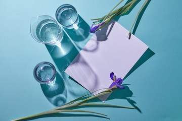 Spring composition of glass vases and purple flowers on a blue background. Flat lay.