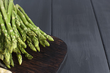 Green asparagus, on a wooden board on a table. Summer vegetables. Healthy food. A vegetarian. Free space for text.