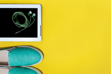 Stylish aquamarine womans shoes tablet and green earphones. Concept of summer walking and camping...