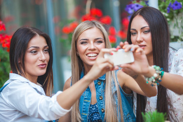 Group of attractive young women making selfie at the cafe and having fun