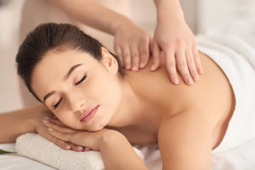 Fototapeta na wymiar Young woman receiving massage in spa salon