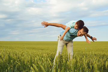 Father and son play in nature. Father's Day.