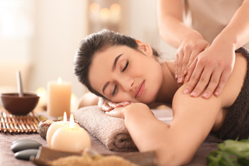 Fototapeta na wymiar Young woman receiving massage in spa salon