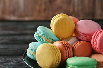 Plate with colorful macarons on table