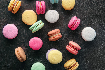 Colorful macarons on dark background, top view