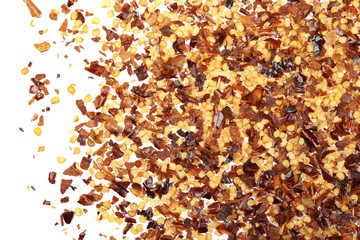 Crushed red cayenne pepper, dried chili flakes and seeds pile isolated on white background, top view