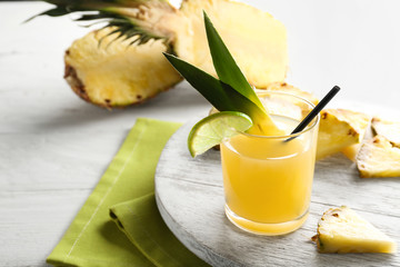 Glass of pineapple juice on wooden tray