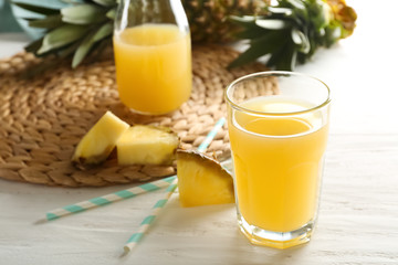 Glass of pineapple juice on wooden table