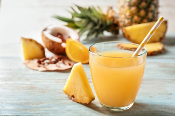 Glass of pineapple juice on wooden table