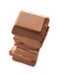 Pieces of milk chocolate on white background