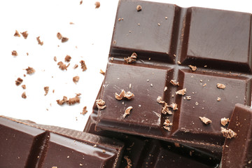Pieces of dark chocolate on white background, closeup
