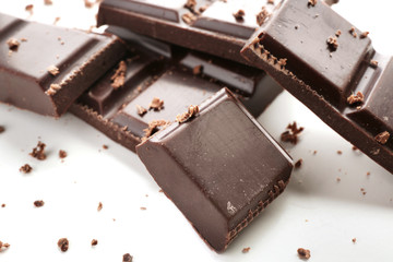 Pieces of dark chocolate on white background, closeup