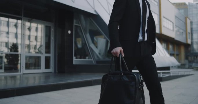 Closeup business man walking down the business center holding his briefcase