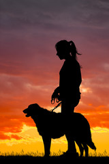 girl and dog silhouette at sunset
