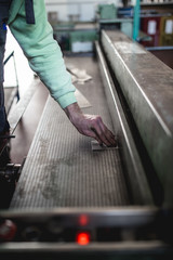 Metallurgy heavy industry. Factory for production of heavy pellet stoves and boilers. Worker hands close up. Extremely dark conditions and visible noise.