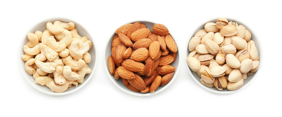 Different nuts in bowls on white background
