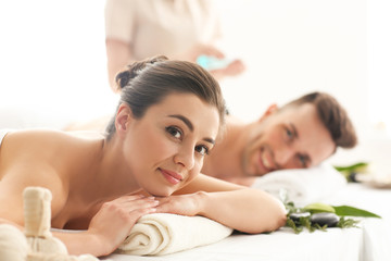 Obraz na płótnie Canvas Happy young couple having massage in spa salon