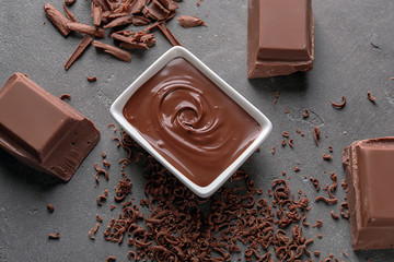 Composition with tasty melted chocolate on grey background