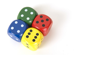 Four colorful gaming dices on a white background background seen from above lying next to each other