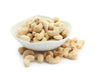 Bowl with tasty cashew nuts on white background