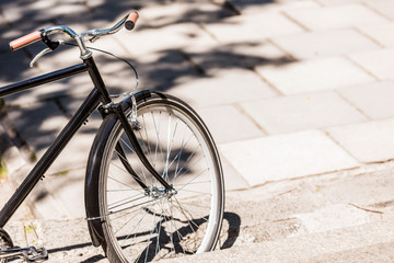Fototapeta na wymiar close up view of black retro bicycle parked on street