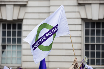 A person with a gender pay equal banner at a political protest march