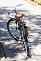 Naklejka premium close up view of black retro bicycle parked on street