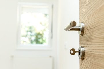New apartment - House key in the door to modern living room