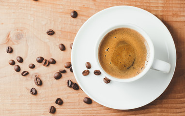 Coffee cup and beans on wooden background