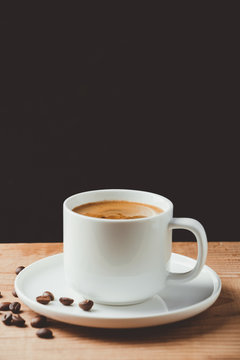 Espresso coffee cup on wooden table and dark background