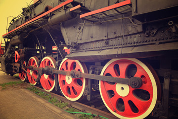 Old black steam locomotive with red wheels