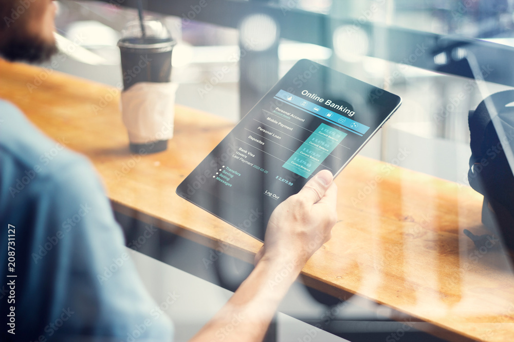 Aufkleber Man hand using online banking on tablet screen device in coffee shop. Technology Ecommerce Commercial. Online payment digital and shopping on network connection. All on tablet screen are designed up.