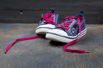 Blue Sports shoes with pink shoelaces on the floor