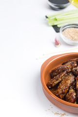 Traditional Asian stir fry chicken wings with sesame and vegetables. Copy space for text