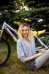 young woman in a hat with a bike in the park. Active people. Outdoors