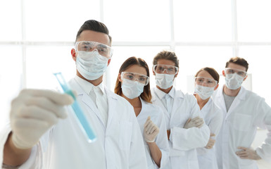 background image is a group of medical workers working with liquids in laboratory