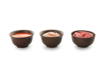 Bowls with red sauce on white background
