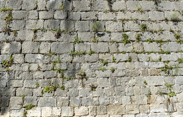 Old stone castle wall made of stone brick slabs.