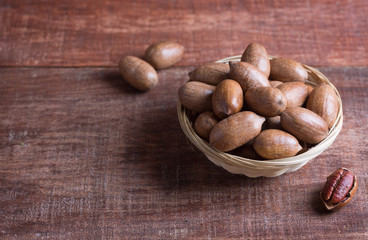 Pecan nuts in a bowl on a wooden table
