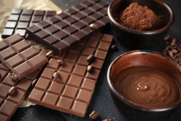 Composition with tasty chocolate and cocoa powder on table
