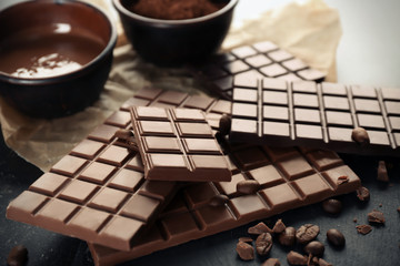 Tasty chocolate and coffee beans on table